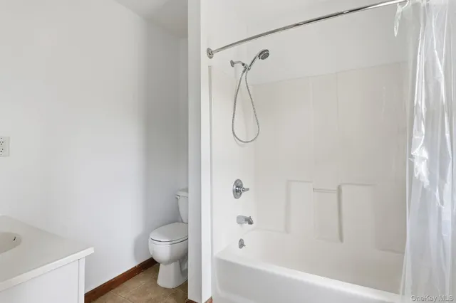 a bathroom with a granite countertop bathtub shower and toilet