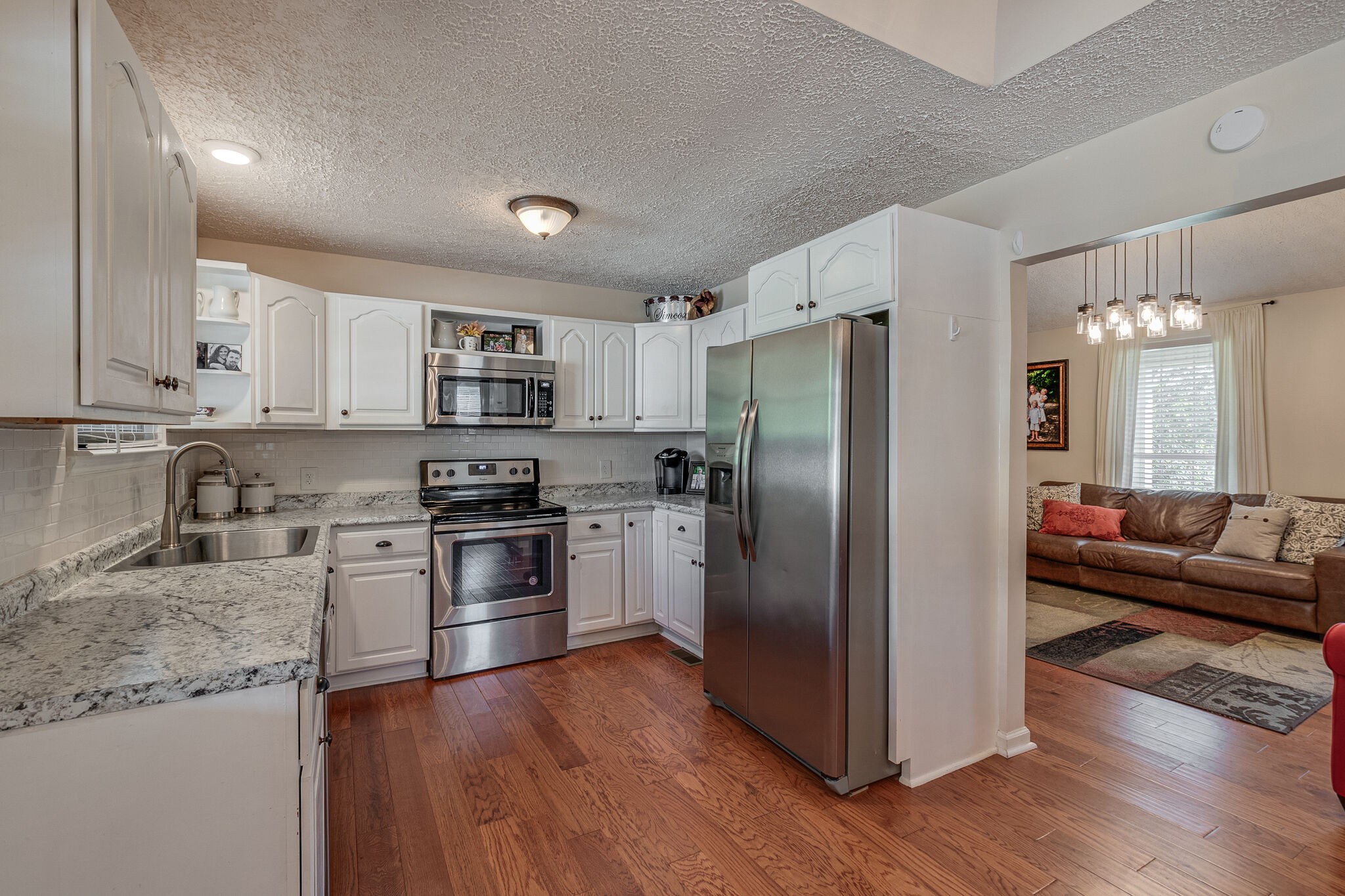 1686 Mann Road Lebanon, TN 37087 - Photo 10 of 31 a kitchen with granite countertop stainless steel appliances a refrigerator a stove top oven and wooden floors