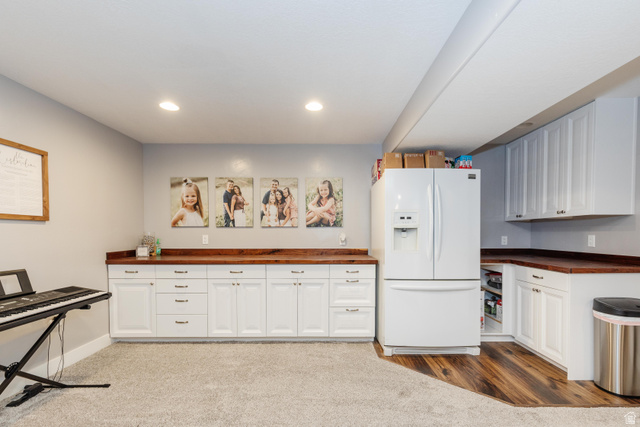 972 West 2840th Street South Logan, UT 84321 - Photo 23 of 46 Recreation area featuring extensive white cabinetry with wood-finish countertops, recessed lighting, and a combination of carpet and wood-finish flooring