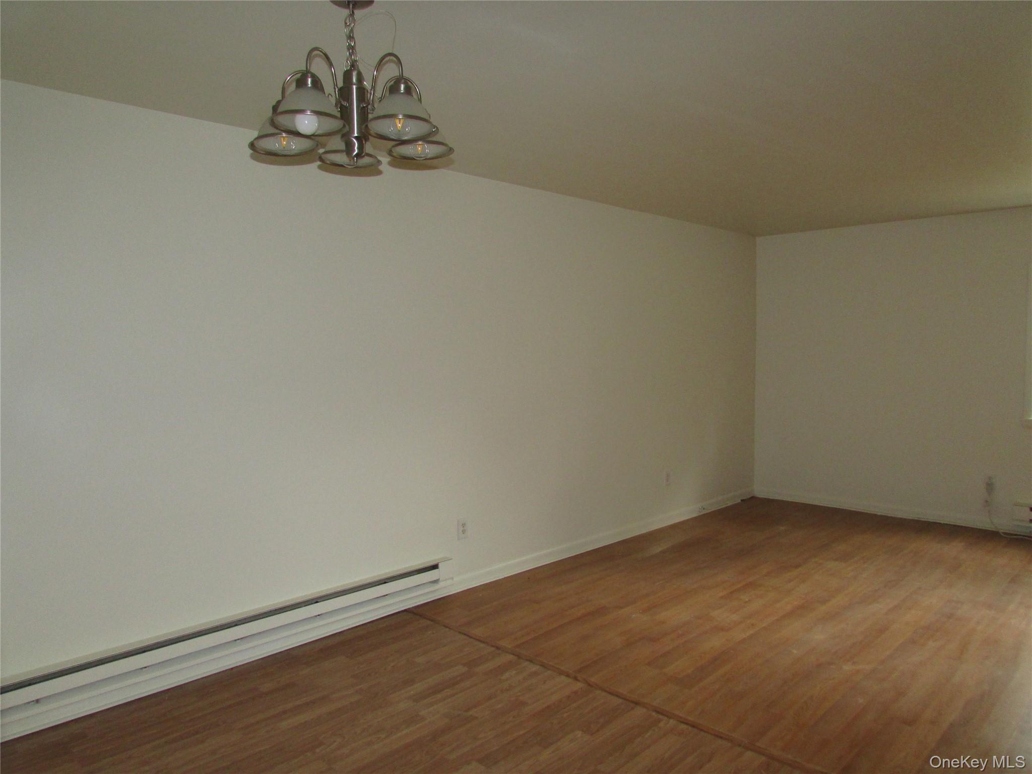 9 White Gate Road, Unit J Wappingers Falls, NY 12590 - Photo 4 of 17 Dining Area with a baseboard radiator and a chandelier