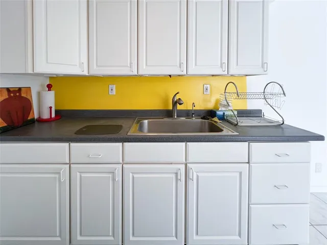 a kitchen with white cabinets and a sink