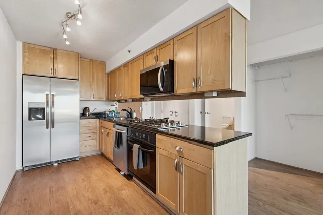 a kitchen with stainless steel appliances granite countertop a sink stove and refrigerator
