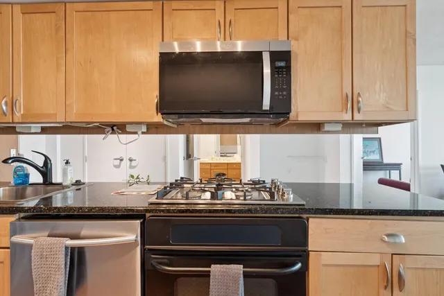 a kitchen with stainless steel appliances granite countertop a stove and a microwave