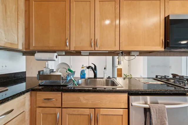 a kitchen with stainless steel appliances granite countertop a sink a stove and a microwave