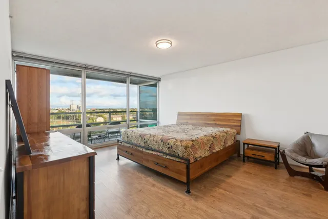 a bedroom with a bed and large window