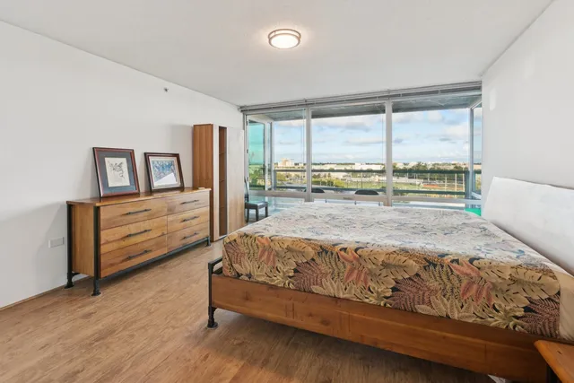 a bedroom with a bed and large windows