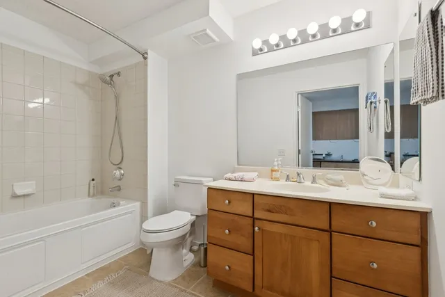 a bathroom with a double vanity sink toilet mirror and bathtub