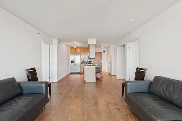a living room with furniture and a view of kitchen