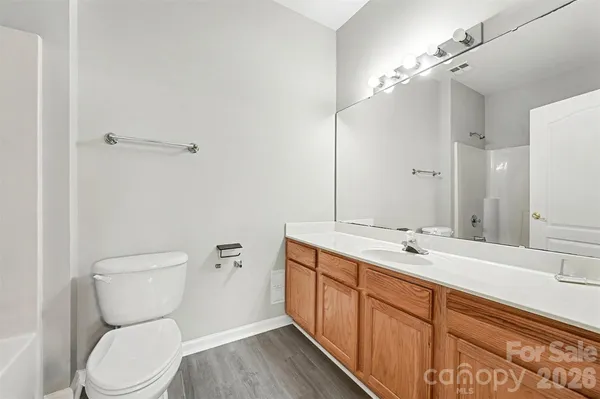 a bathroom with a granite countertop toilet sink and mirror