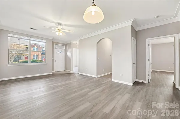 an empty room with wooden floor and windows