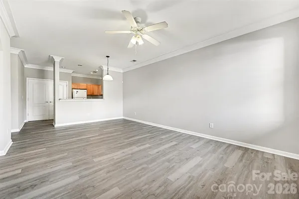 an empty room with wooden floor and ceiling fan