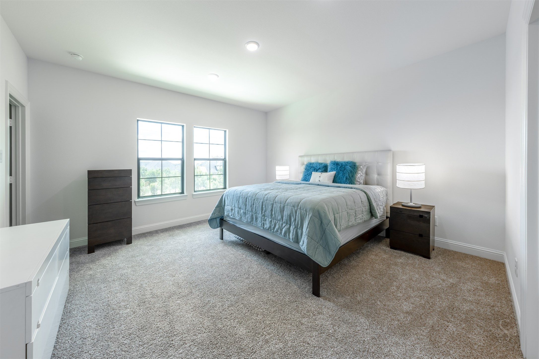27919 Indigo Ridge Drive Fulshear, TX 77441 - Photo 36 of 50 This spacious upstairs bedroom offers an airy, peaceful setting with soft natural light pouring in through the large windows. With plush carpeting and plenty of room for a full bedroom suite, it’s an inviting retreat perfect for guests or family members.