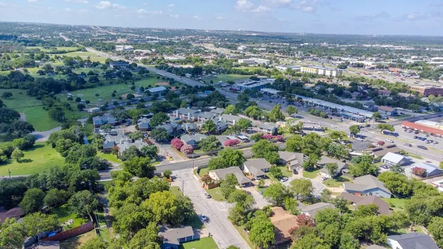 an aerial view of a house with lots of green space