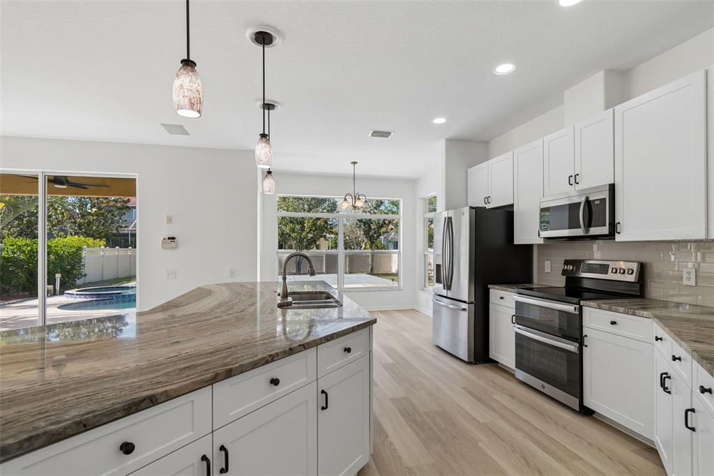 2300 Hannah Way South Dunedin, FL 34698 - Photo 7 of 49 a kitchen with stainless steel appliances granite countertop a sink a stove a refrigerator with grey cabinets