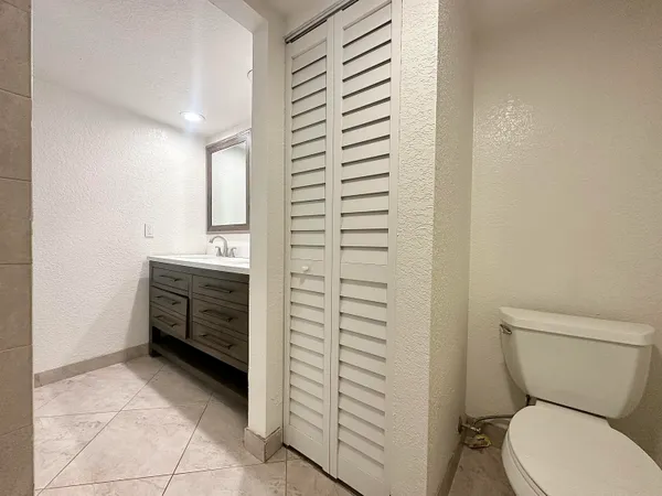 a bathroom with a toilet a sink and mirror