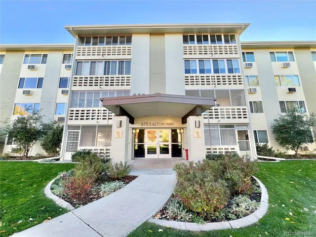 a front view of a building with a garden and plants