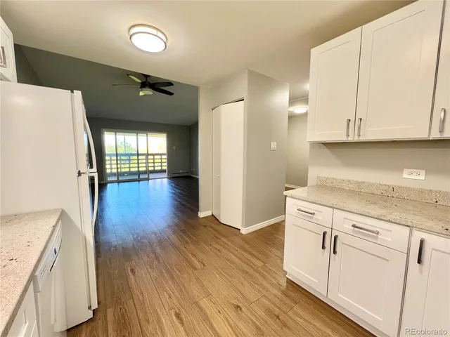a kitchen with granite countertop white cabinets and white appliances
