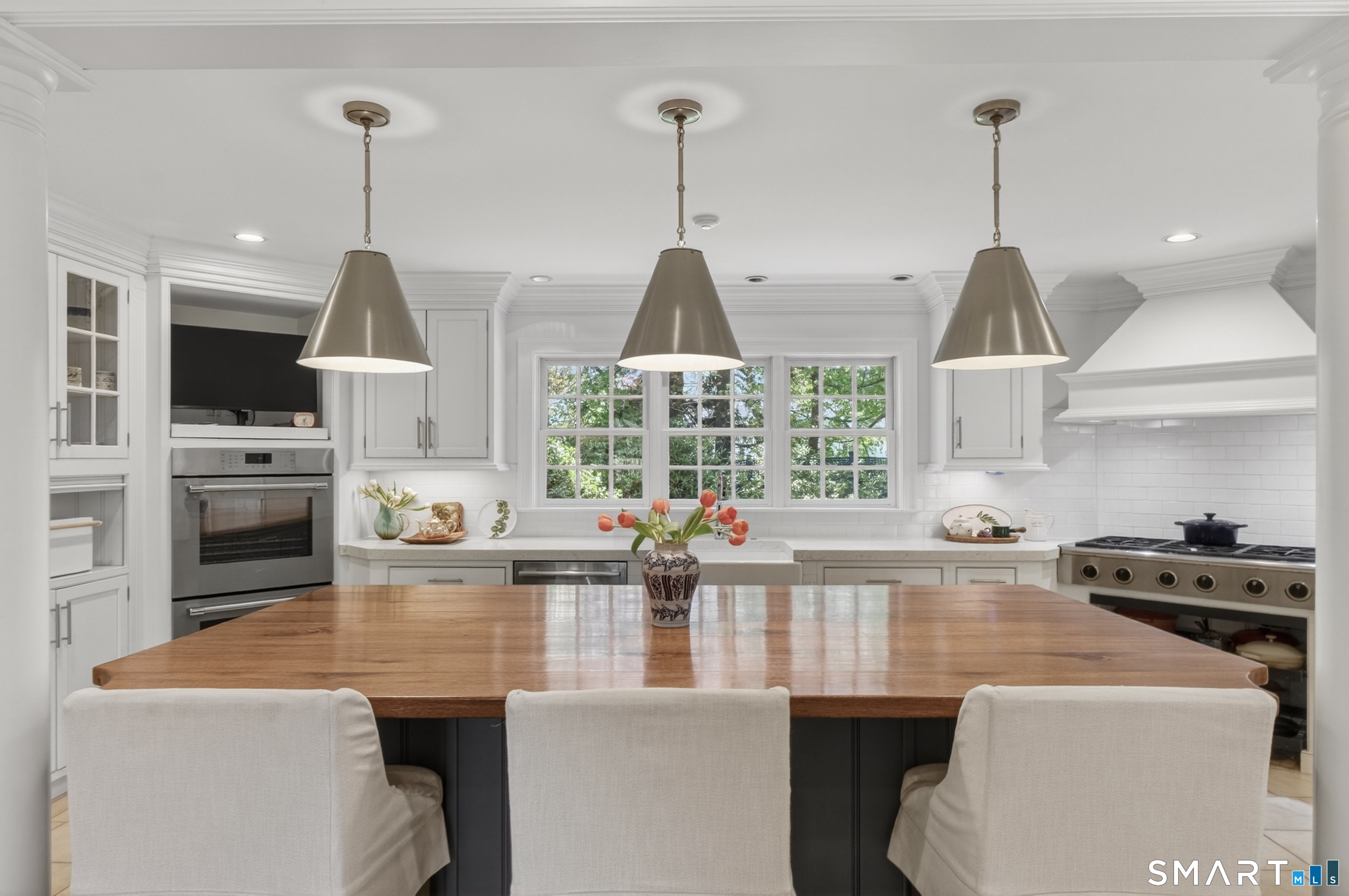 41 Peaceable Street Ridgefield, CT 06877 - Photo 13 of 40 a kitchen with stainless steel appliances a dining table chairs and white cabinets