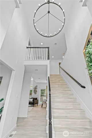 a view of an entryway wooden floor and a kitchen view