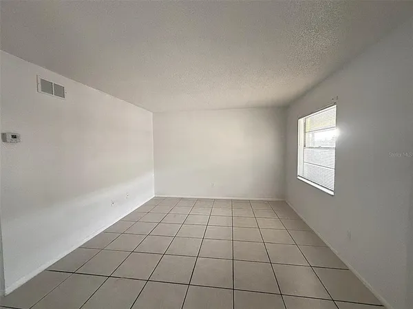 a view of a refrigerator in kitchen and white cabinets