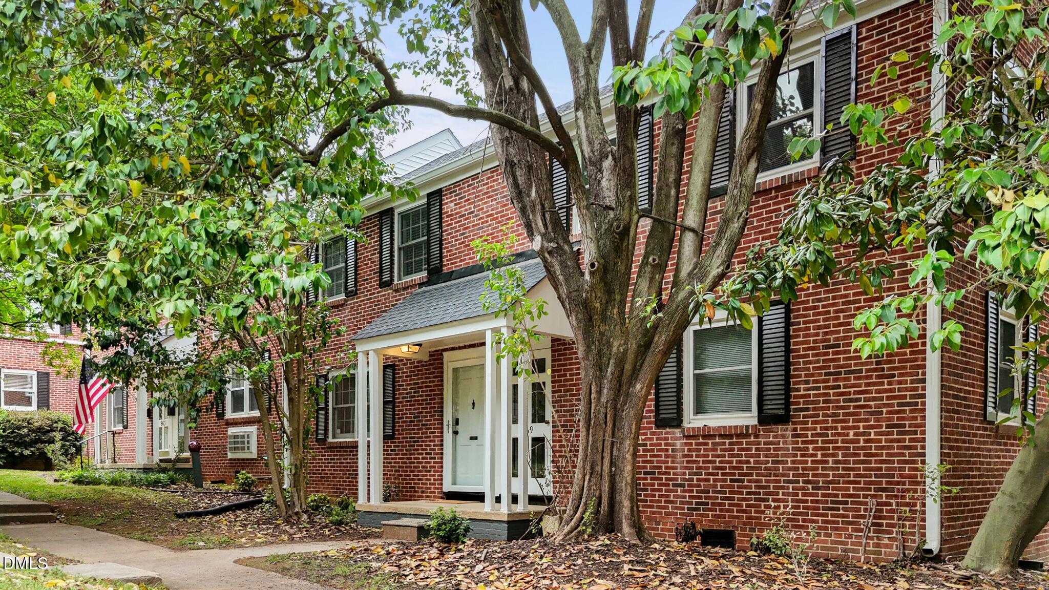 a front view of a house with a tree