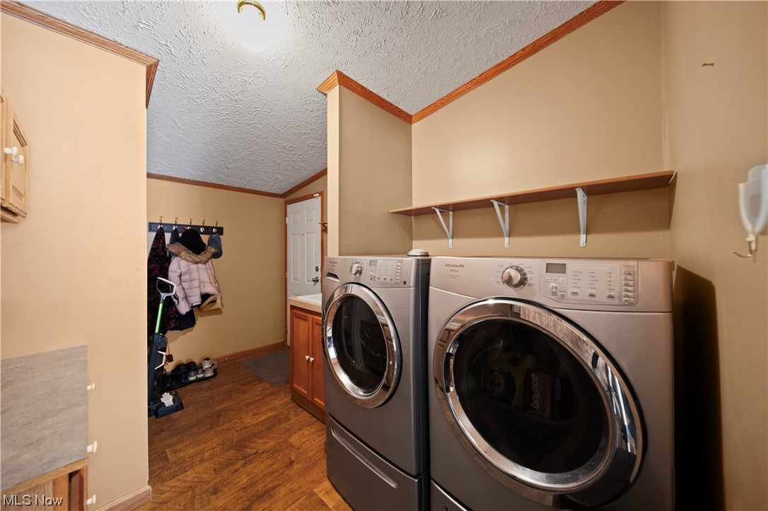 4951 Lane Road Perry, OH 44081 - Photo 22 of 31 Laundry area with washing machine and clothes dryer, cabinets, dark hardwood / wood-style flooring, and a textured ceiling