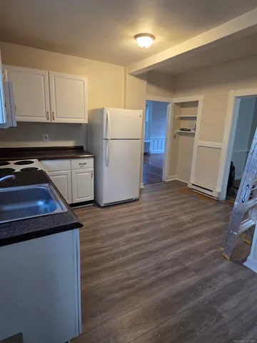 a kitchen with a refrigerator sink and cabinets