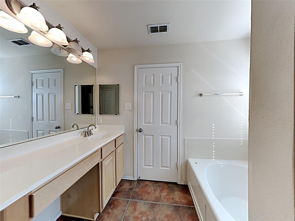3251 Torio Grand Prairie, TX 75054 - Photo 9 of 17 a bathroom with a tub a double vanity sink and a mirror