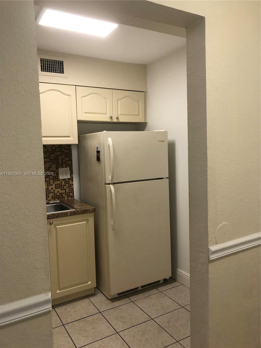 9467 Southwest 76th Street, Unit Q3 Miami, FL 33173 - Photo 4 of 18 a white refrigerator freezer and a stove in a kitchen