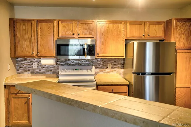 a kitchen with a refrigerator a stove a sink and cabinets