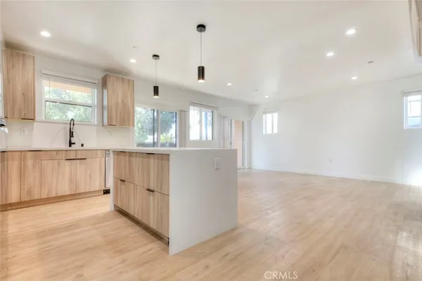 a large kitchen with stainless steel appliances granite countertop a large counter top and a wooden floors