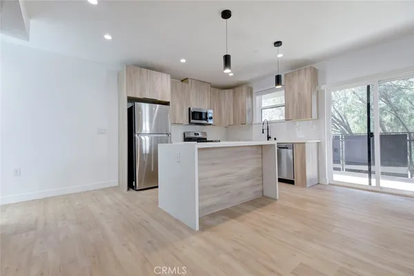 a kitchen with stainless steel appliances a refrigerator sink and cabinets