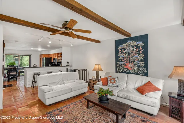 a living room with furniture and kitchen view