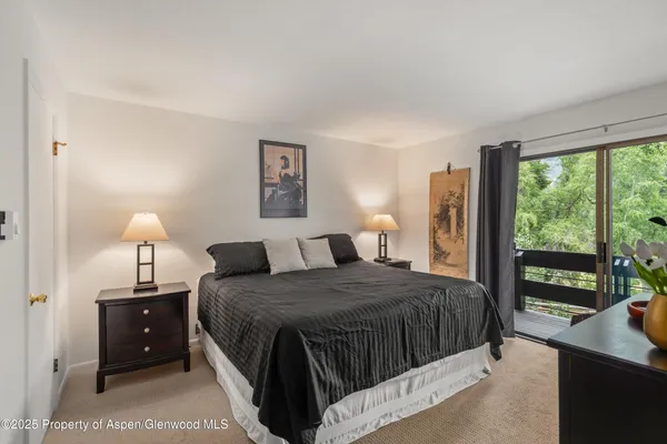 a bedroom with a bed and a lamp next to a window