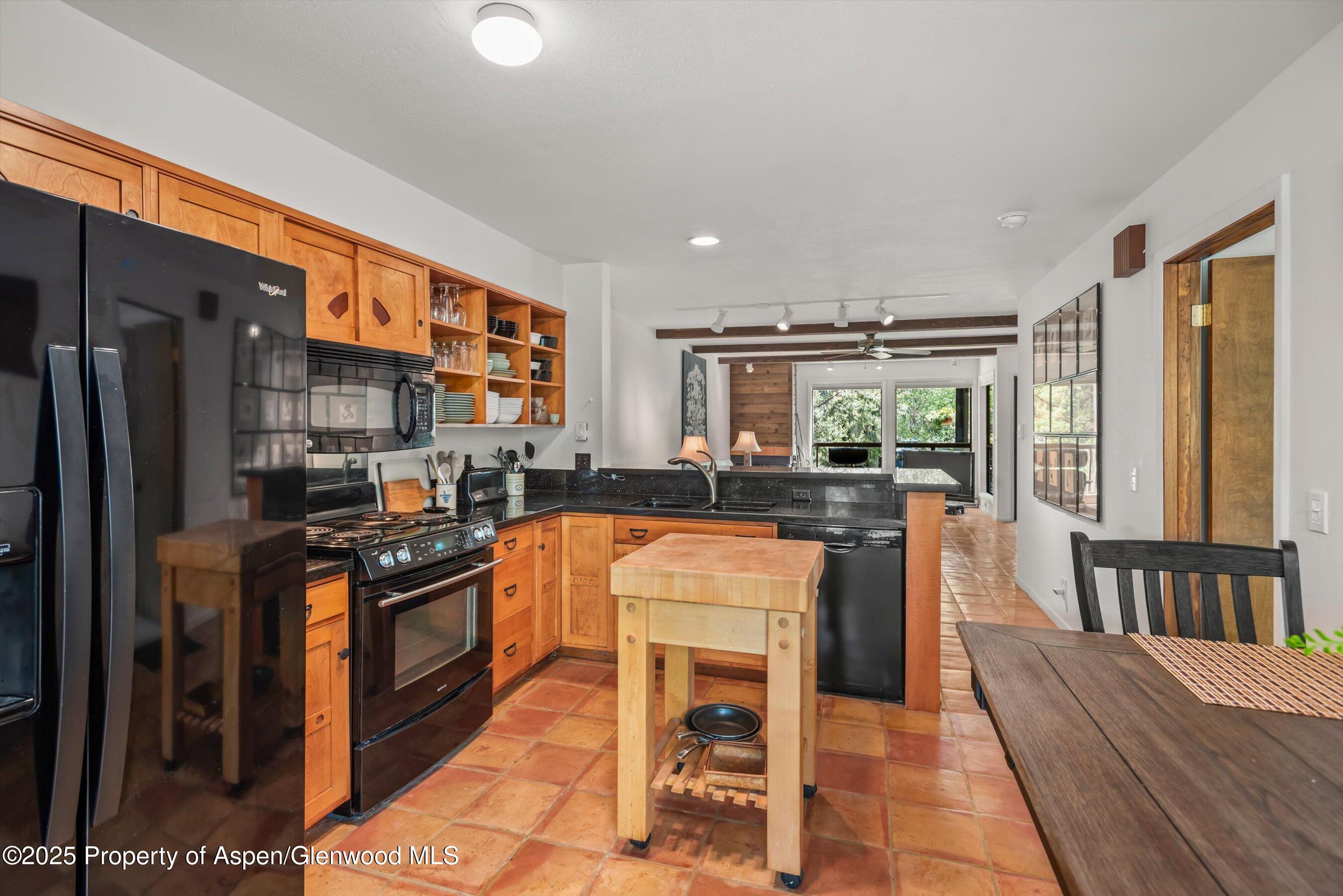 824 East Hopkins Avenue, Unit 102 AND 202 Aspen, CO 81611 - Photo 6 of 19 a kitchen with stainless steel appliances granite countertop a refrigerator a stove top oven and a dining table with wooden floor