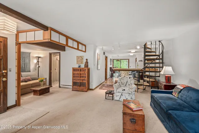a living room with furniture gym equipment and a chandelier