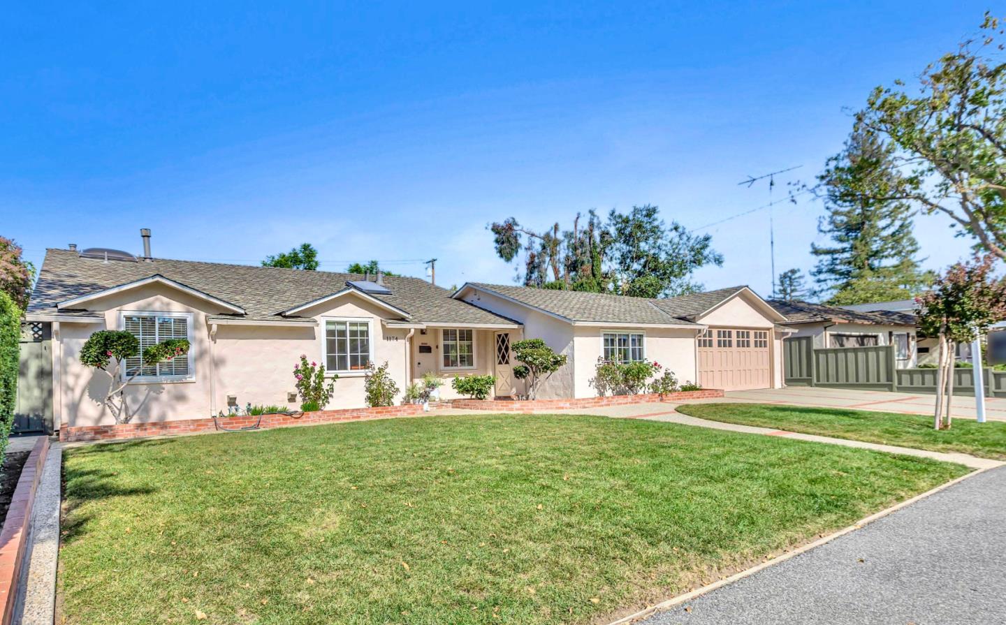 1174 Fordham Way Mountain View, CA 94040 - Photo 2 of 36 a front view of a house with a garden and trees