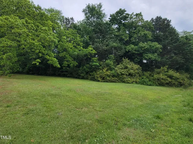 a view of a city street with a building and trees in the background