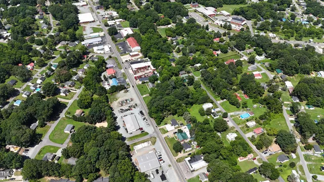 an aerial view of residential house with outdoor space and trees all around