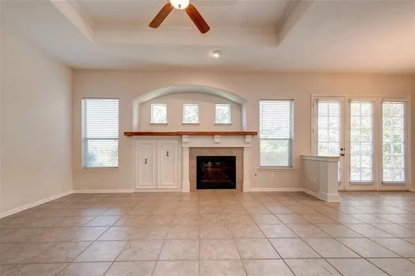 an empty room with windows and fireplace