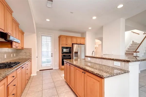 a large kitchen with stainless steel appliances granite countertop a sink and cabinets