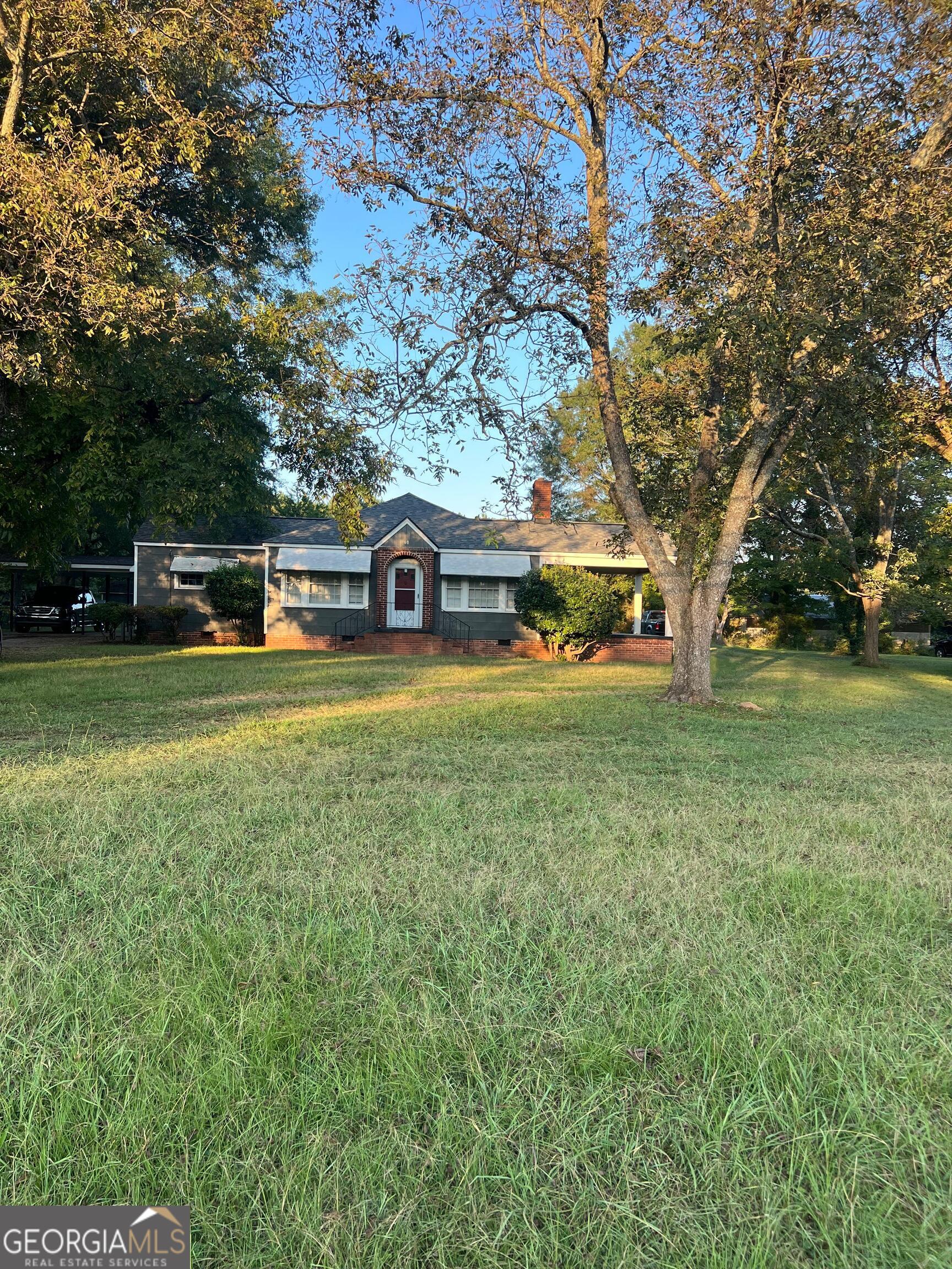 60 North East Main Street Hampton, GA 30228 - Photo 10 of 17 a view of a house with a big yard and large trees