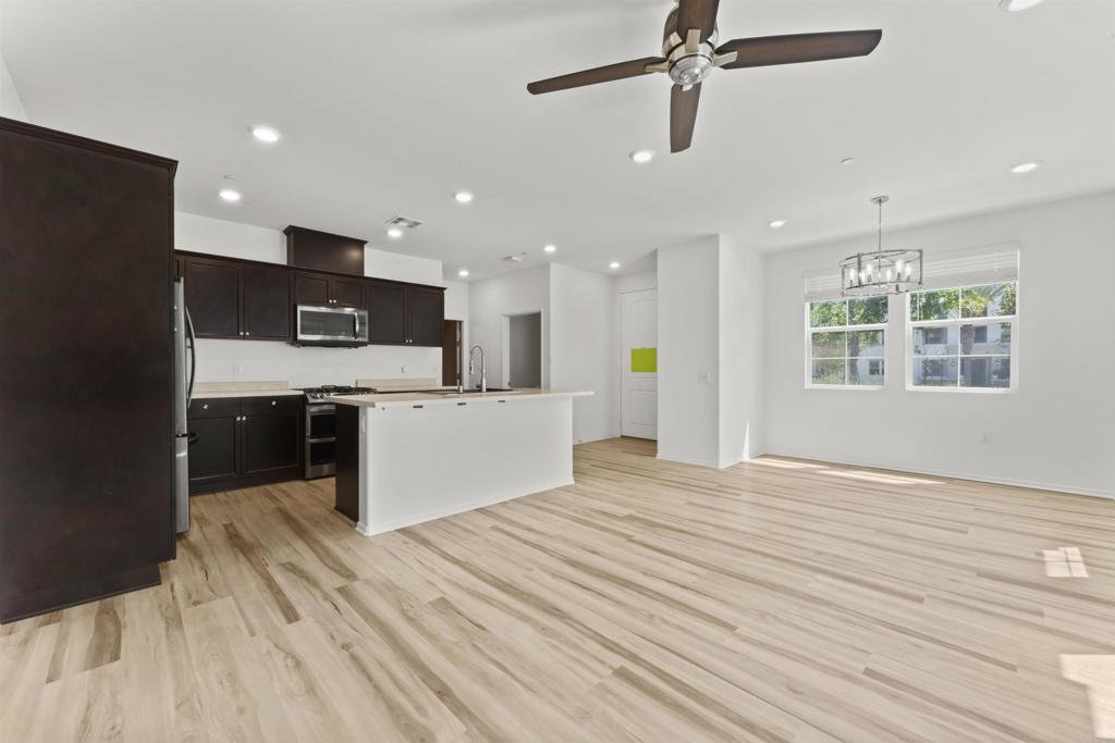 30320 Town Square Drive Menifee, CA 92584 - Photo 3 of 28 a view of kitchen with kitchen island wooden floors appliances and cabinets