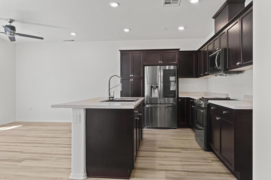 30320 Town Square Drive Menifee, CA 92584 - Photo 4 of 28 a kitchen with stainless steel appliances granite countertop a refrigerator and a sink