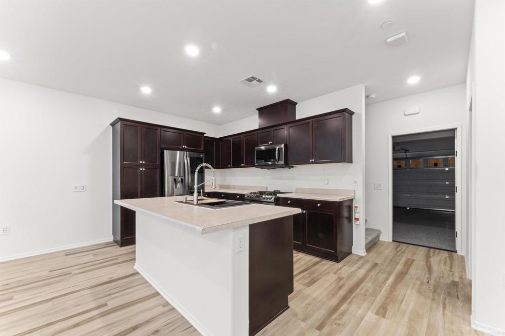 30320 Town Square Drive Menifee, CA 92584 - Photo 5 of 28 a kitchen with stainless steel appliances a stove refrigerator sink and cabinets