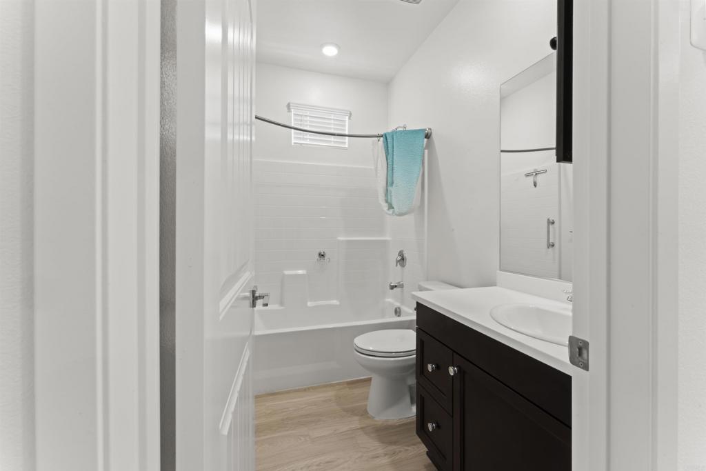 30320 Town Square Drive Menifee, CA 92584 - Photo 9 of 28 a bathroom with a granite countertop sink a toilet and shower