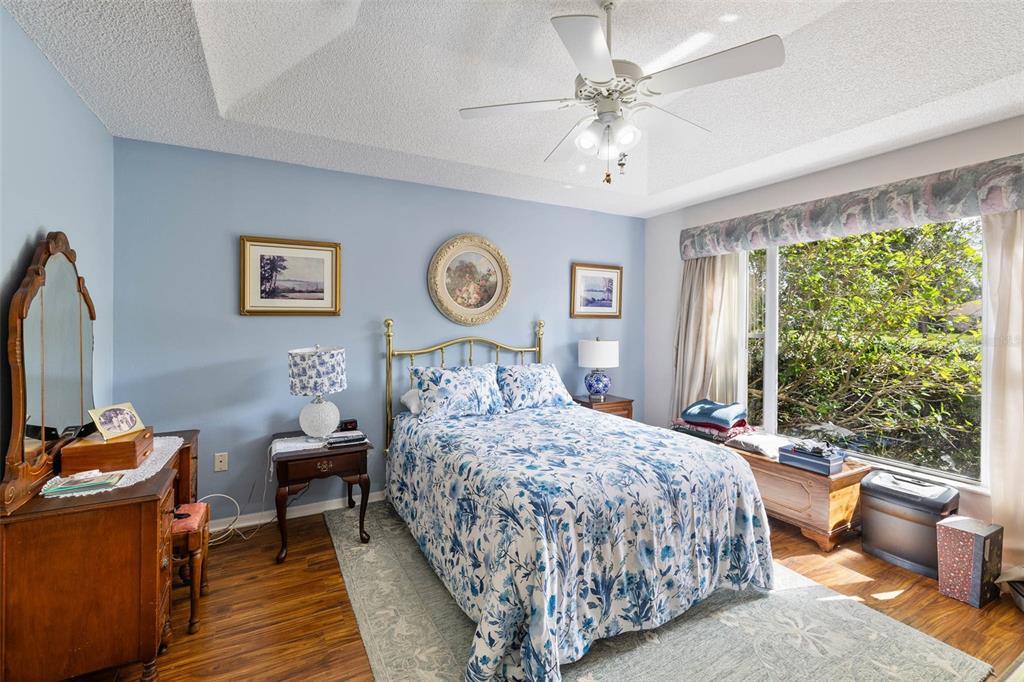 14462 Tamarind Loop Spring Hill, FL 34609 - Photo 11 of 28 a bedroom with a bed and a chandelier