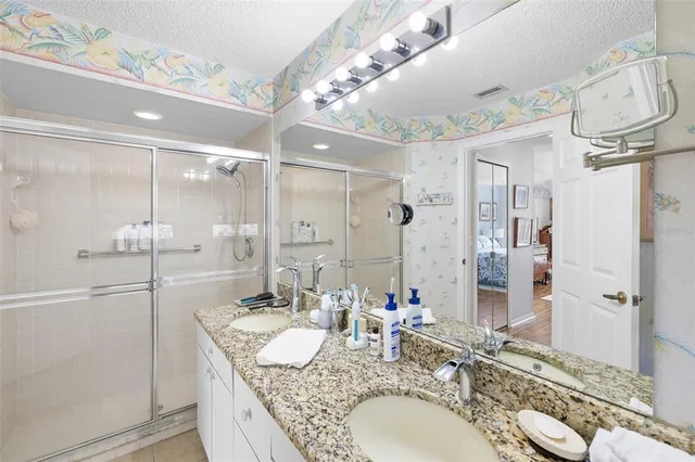 a bathroom with a granite countertop double vanity sink and a mirror