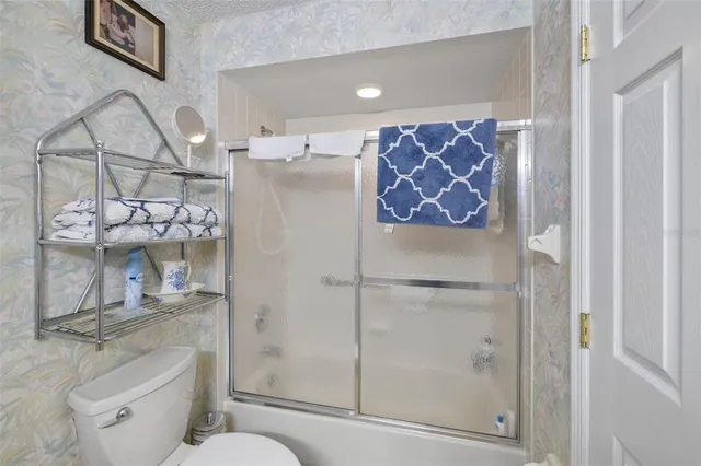 a bathroom with a shower toilet and sink
