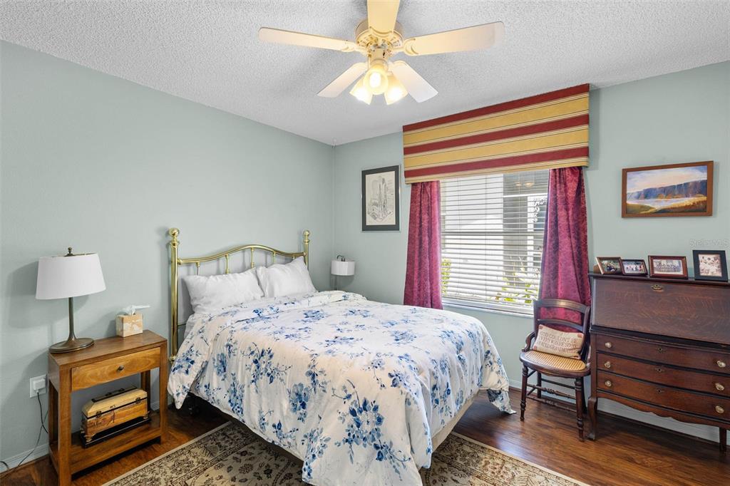 14462 Tamarind Loop Spring Hill, FL 34609 - Photo 17 of 28 a bedroom with a bed a dresser and a chandelier